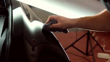 Adam elinde bir parlatıcı tutuyor ve serviste nano seramik ile arabayı parlatıyor..