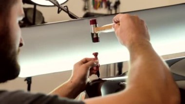 Teknisyen araba servisinde boya kullanmadan göçükleri temizliyor. Araba tamiratı teknolojisi..