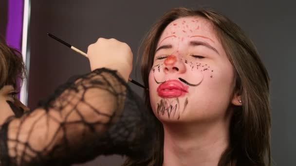 Twee meisjes gaan naar het Halloween feest en bereiden zich voor op het tekenen van schilderij op het gezicht met behulp van rode en zwarte kleur. — Stockvideo