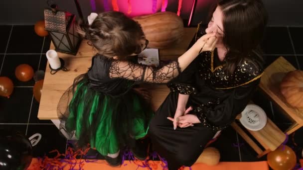Две Сестры Готовятся Хэллоуинской Вечеринке Одетые Волшебные Костюмы Рисуют Маску — стоковое видео