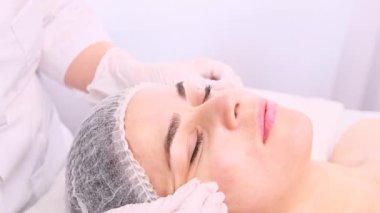 Kafası kapalı genç bir kadın cilt bakımını üstleniyor, bir güzellik uzmanından gençleştirme ameliyatı oluyor..