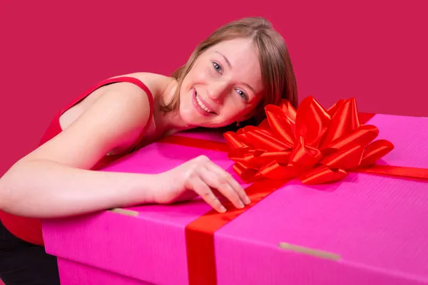 Güzel, mutlu, genç bir kadının fotoğrafını çek. Kafasını büyük pembe renkli hediye kutusunda tut ve şu kutuda da fiyonk olsun.. — Stok fotoğraf