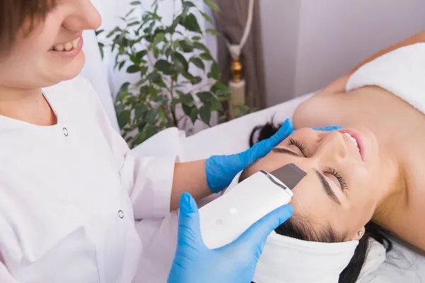 Junge hübsche Frau erhält Ultraschall-Reinigung Gesichtsbehandlung im Schönheitssalon, Kosmetologie Gesichtshaut Behandlungskonzept. — Stockfoto