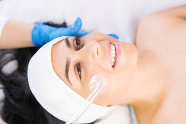 Kozmetik uzmanı, güzellik salonunda, kozmetolojide ve profesyonel cilt bakımında güzel bir kadının derisini yüzme prosedürünü uyguluyor..