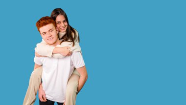 Mutlu duygular ve duygular, sevgilisinin arkasından yükselen sevgi dolu bir çift, mavi arka plan, kopyalama alanı..