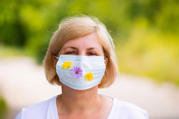 Protection against contagious disease, coronavirus, woman in hygienic face surgical medical mask with flowers to prevent infection. — 图库照片