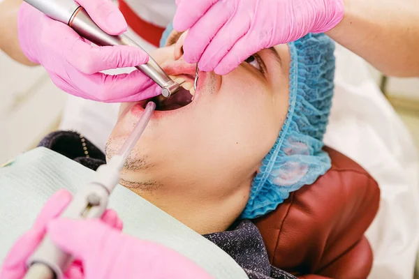 Стоматолог і стоматолог оглядають зуби пацієнта і роблять лікування зубів у стоматологічній клініці . — стокове фото