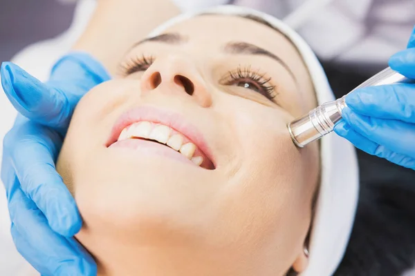 Closeup photo of smiling woman receiving face cleaning procedure in cosmetology clinic, vacuum cleaning. — Stockfoto