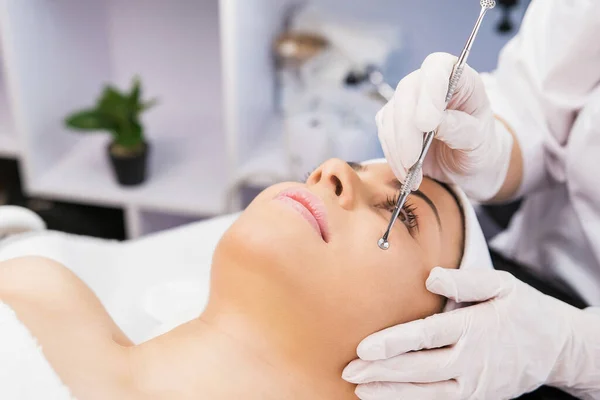 Schöne Frau liegt auf dem Massagetisch und bekommt Verfahren gegen Akne in der Kosmetologie Klinik, Schönheitskonzept. — Stockfoto