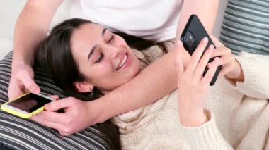 Bir kadının erkek arkadaşının dizlerinin üzerine çöküp gülümsediği ve elinde cep telefonuyla sohbet ettiği videoyu kapat..