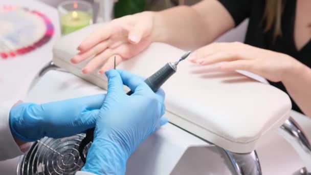 Close up video di un manicure cambiando ugelli sulla lima elettrica, trapano per unghie per lucidare manicure chiodo cliente donna in un salone di bellezza. — Video Stock