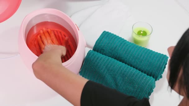 Mujer en el salón de belleza consiguiendo parrafina procedimiento de baño para hacer sus manos suaves y hermosas, concepto de la piel de la salud. — Vídeos de Stock