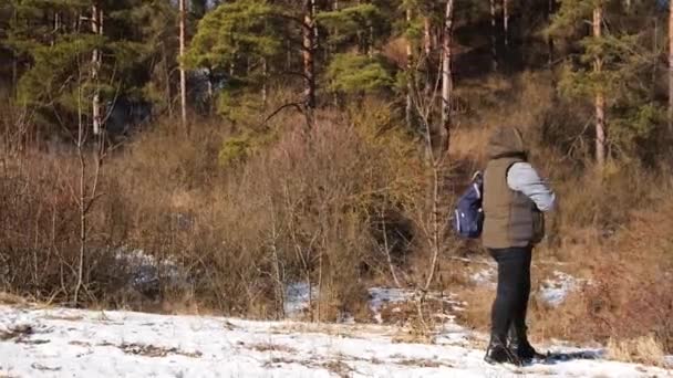 Femeie turist în picioare pe drumul din apropierea pădurii cu rucsac și hartă în mâna ei în căutarea destinației ea trebuie să meargă. — Videoclip de stoc