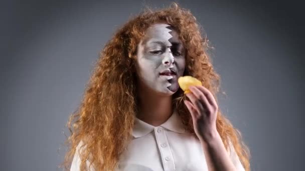 Fan footbal woman with painted face in Qatar national flag eating chips being at the stadium where playing her favorite team. — Vídeo de Stock