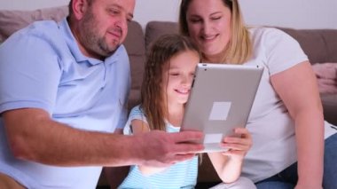 Mutlu ve sevgi dolu bir aile arkadaşlarıyla sohbet etmek için tablet kullanır ve hafta sonları evde eğlenir..