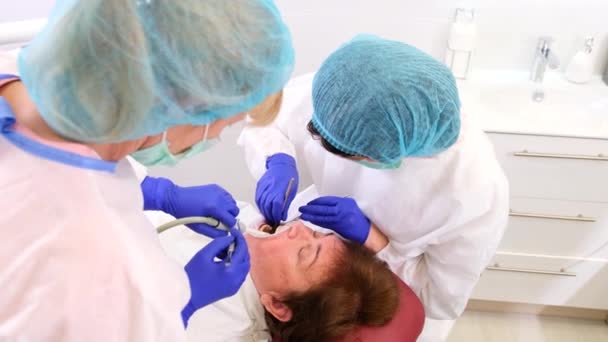 Dva zdravotničtí pracovníci zubař a její útočník ošetřující žena pacient stomatologické zdraví v zubní klinice, ústní zdravotní koncepce. — Stock video