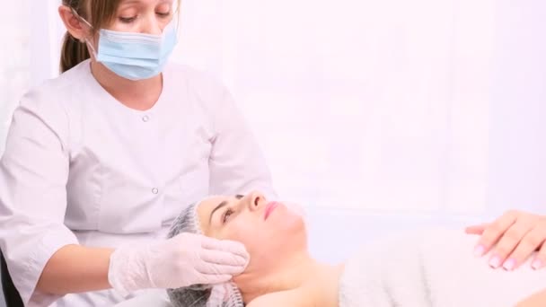Kozmetik uzmanının güzellik salonu kozmetoloji tedavisinde yüz temizliği yapan rahat bir kadın.. — Stok video