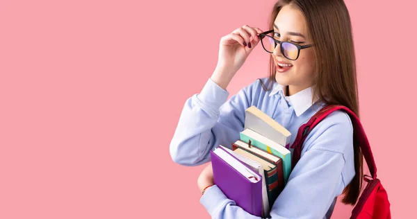 Boční pohled fotografie školního dospívající dívky v uniformě s batohem a knihami mrknutí odsunout brýle, vysokoškolský koncept. — Stock fotografie
