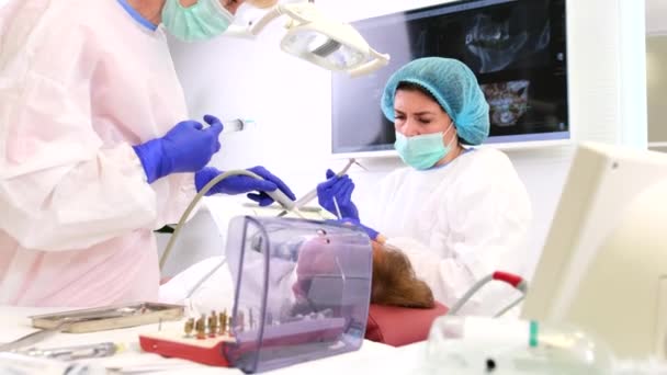 Deux travailleurs médicaux médecin dentiste et un assistant traitant un patient en clinique de stomatologie, concept de dents de santé. — Video