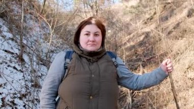 Mutlu turist kadının yolculuğunu sürdürdüğü videoyu kapat. Sıcak bir şekilde ve sırt çantasıyla tepede dikiliyordu..