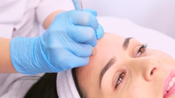 Профессиональный косметолог в синих перчатках делает процедуру микродермабразии очищающего лица с вакуумным удалением угрей. — стоковое видео