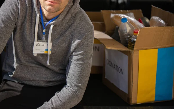 Savaştan kaçan Ukraynalı mülteciler için yardım derneğiyle işe ara veren gönüllü bir adamın kesilmiş fotoğrafı..