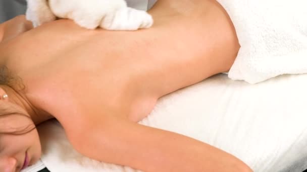 Masajista mujer limpiando cliente de nuevo con una toalla blanca después del masaje en el salón de spa, relajarse y calmar el concepto de procedimiento. — Vídeo de stock