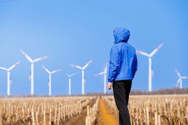 Üzüm bağındaki rüzgar türbinlerine bakan adam mühendis. Kırsal alternatif enerji kavramı. Yüksek kalite fotoğraf