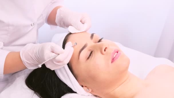Confiante em si bela mulher recebendo procedimento para limpar o rosto com um aparelho de aço de cravos e acne. — Vídeo de Stock