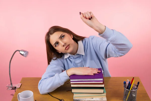 Jovem adolescente menina da escola sentada na mesa intitulada sua cabeça no ombro na mão mantendo os livros e outra mão aperta em um punho levanta-se. — Fotografia de Stock