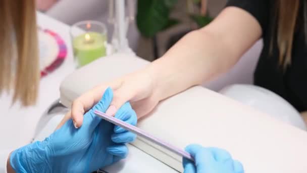Manikűrös tiszta körömápoló professzionális körömreszelő manikűr szépségszalonban viselő kék kesztyű, szépség és gondozás koncepció. — Stock videók