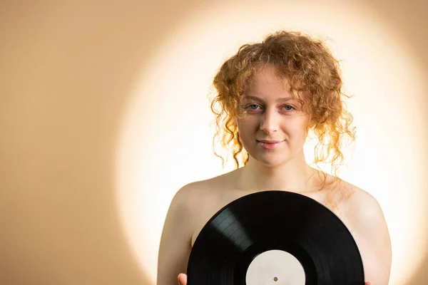 性感红头发的年轻女子用圆圆的无色记录覆盖着她赤裸的乳房 呈黑色 呈现明亮的黄色背景 高质量的照片 — 图库照片