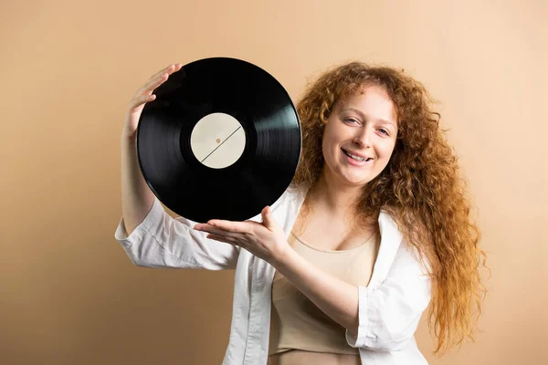 一个红头发的快乐女人的近照 她高举双手 头顶着金色的背景 有着黑胶的记录 高质量的照片 — 图库照片