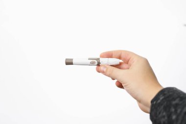 Picture of a man hand holding a lancet for checking blood sugar level by glucose meter on white background, diabetes monitoring concept. High quality photo