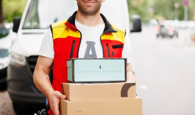 delivery man holding pile of cardboard boxes in front. High quality photo