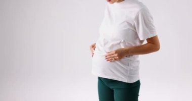 The pregnant lady lifts her white tank top so that the doctor can listen carefully to the babys movements. High quality 4k footage