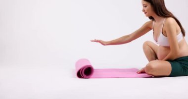 The pregnant lady unfolds the pink carpet and suddenly lies down to relax. High quality 4k footage