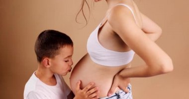 The happy child kisses his soon to arrive brother. He is very eager to get to know you little kid. High quality 4k footage