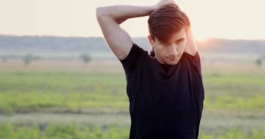 A beautiful sport man stretching neck and arms before going on a run. High quality 4k footage