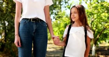 Happy child goes by the hand with mom. The little one will go to primary school. Happy family. High quality 4k footage