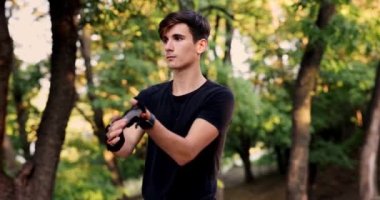 Young sport man warming up at forest before jogging. Men stretching for running exercises. Handsome athlete doing fitness outdoor in park. Healthy lifestyle concept. High quality 4k footage