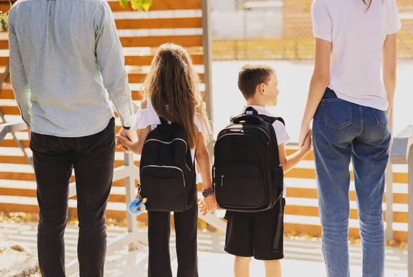 The first day at school, parents and children walk hand in hand on the way to school. High quality photo