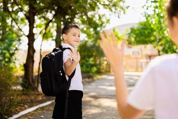 A cute boy says goodbye to his mother on the first day of school. High quality photo