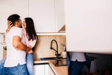 Happy couple in love standing in the kitchen romantically. Big love in their eyes. High quality photo