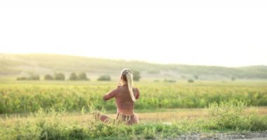Silhouette of young woman practicing yoga on the nature at sunset. Active meditation a relax concept. Woman meditation in nature in the park. Sport recreation concept sunset. High quality 4k footage