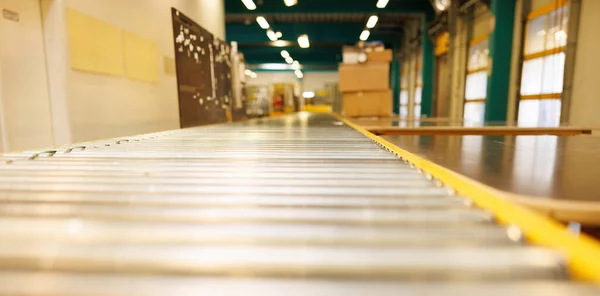 An empty industrial roller conveyor belt in a fully automated factory. Roller conveyor to easily move heavy industrial goods around without the need for humans. High quality photo