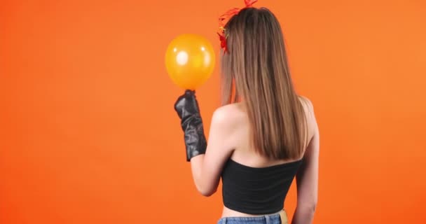 Ein Mädchen mit Halloween-Leichen-Make-up kehrt mit einem Luftballon in der Hand in die Kamera zurück, der ihn zerbricht. Hochwertiges 4k Filmmaterial