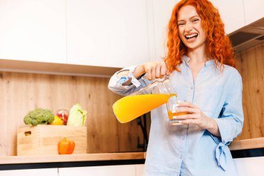 Evdeki mikserde yaptığı detoks suyunu servis eden genç ve güzel bir kadın. Yüksek kalite fotoğraf