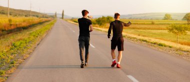 İki sporcu sabah antrenman yapıyor, ikisi de koşmak zorunda oldukları rotayı gösteriyor. Yüksek kalite fotoğraf