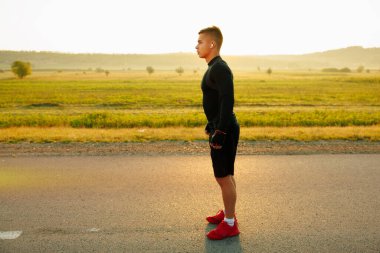 Yakışıklı bir sporcu yarışmaya başlamadan önce başlangıç çizgisinde bir nefes alır. Yüksek kalite fotoğraf